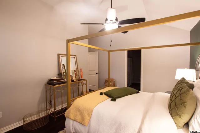 a bedroom with a bed and dresser with mirror