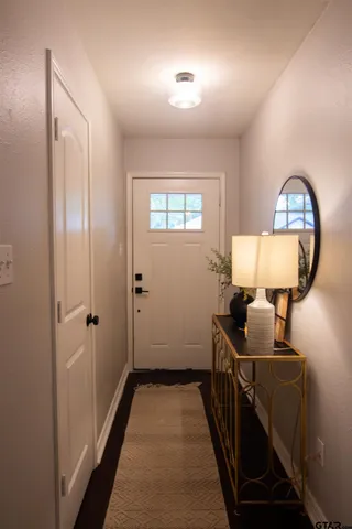 a view of a hallway with wooden floor windows and a bathroom