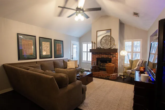 a living room with furniture a fireplace and a flat screen tv