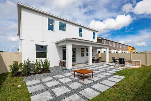 a view of a house with backyard sitting area and garden