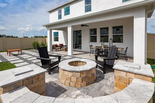 a view of a house with backyard fire pit and a yard