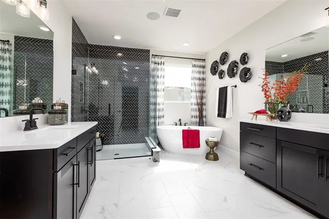 a bathroom with a tub sink mirror and shower