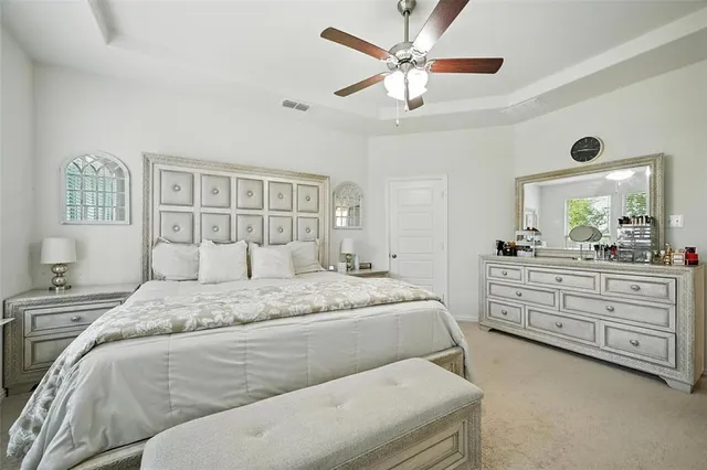 a spacious bedroom with a bed and a dresser