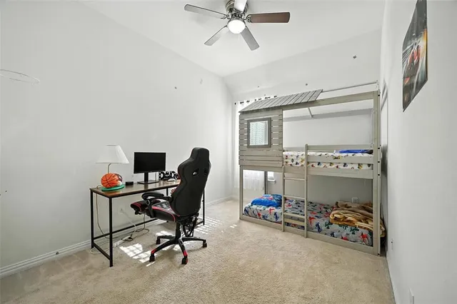 a view of a workspace with furniture and a fan