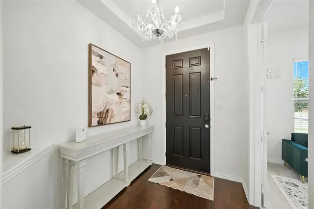 a view of a hallway to a bedroom with wooden floor and cabinet