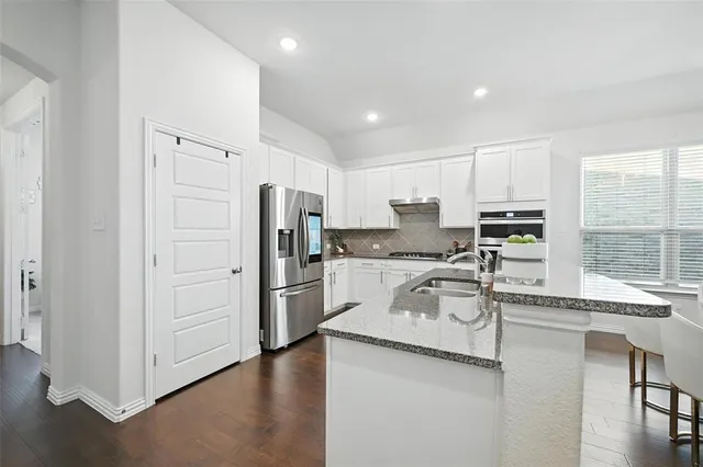 a kitchen with a refrigerator a sink and cabinets