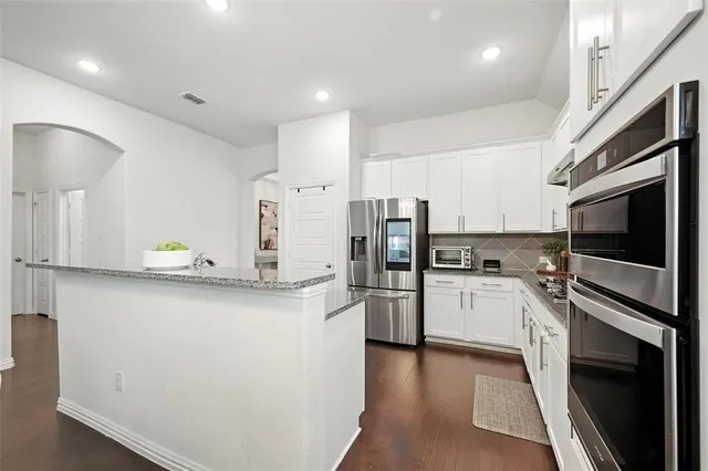 a kitchen with refrigerator and cabinets