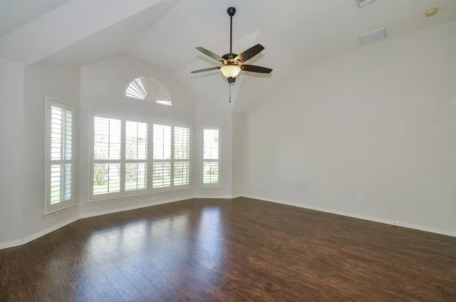 a view of a room with wooden floor and a window