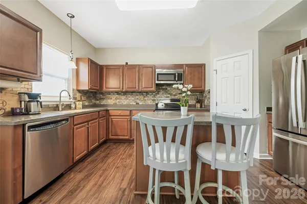a kitchen with stainless steel appliances granite countertop sink stove top oven and cabinets