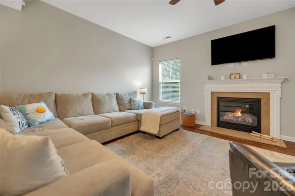 a living room with furniture a fireplace and flat screen tv