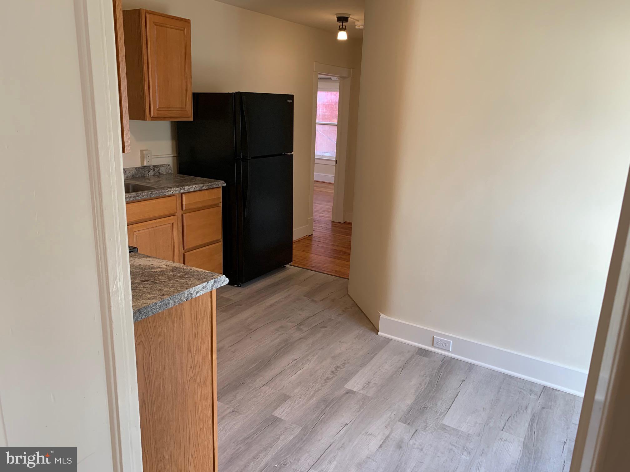 130 East German Street, Unit 201 Shepherdstown, WV 25443 - Photo 6 of 23 a kitchen with a refrigerator and cabinets