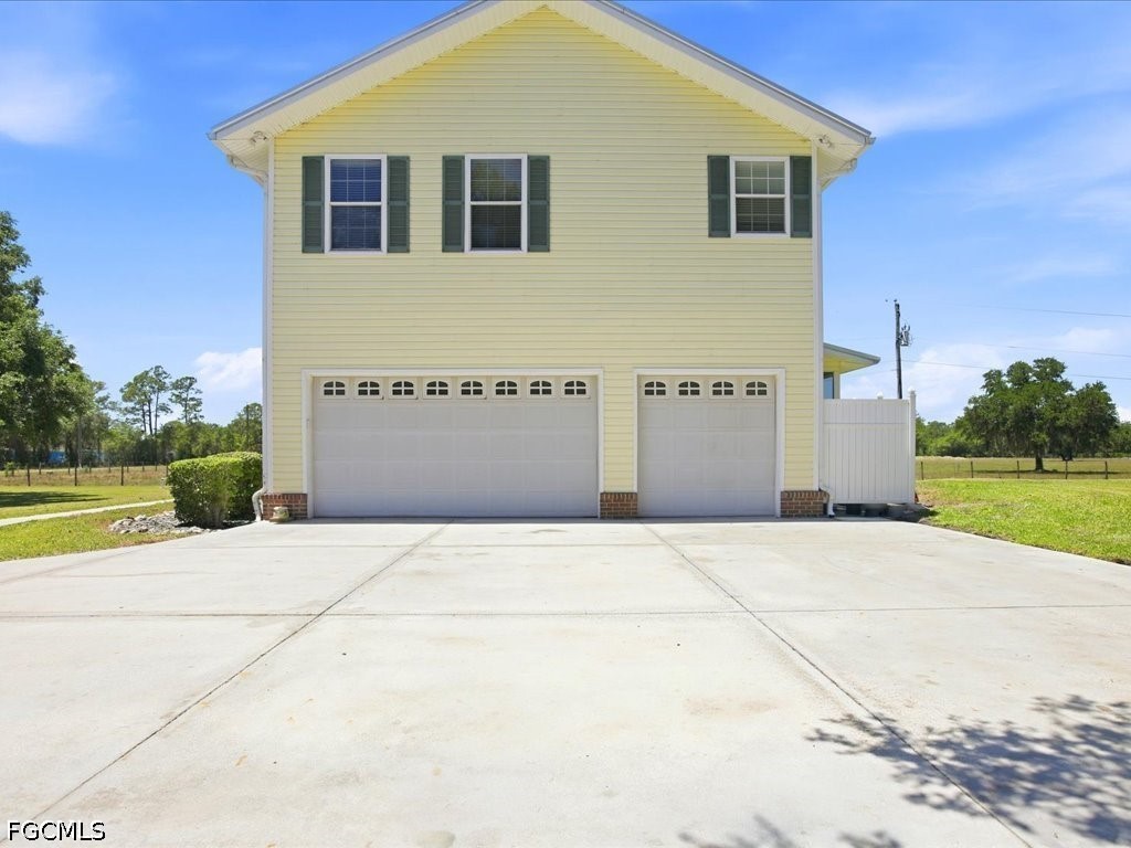 21651 Tuckahoe Road Alva, FL 33920 - Photo 4 of 42 a front view of a house with a yard and garage