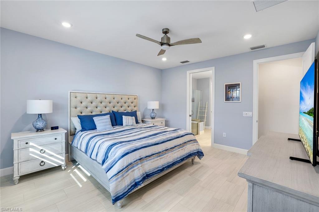 1944 Yellowfin Circle Naples, FL 34114 - Photo 15 of 36 a bedroom with a large bed and a flat tv screen on dresser