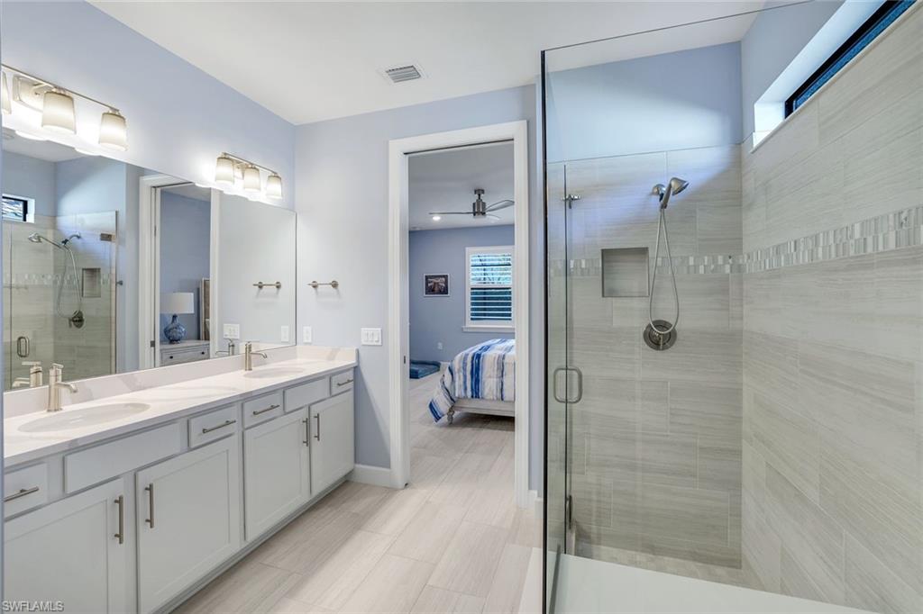 1944 Yellowfin Circle Naples, FL 34114 - Photo 17 of 36 a spacious bathroom with a shower sink and mirror