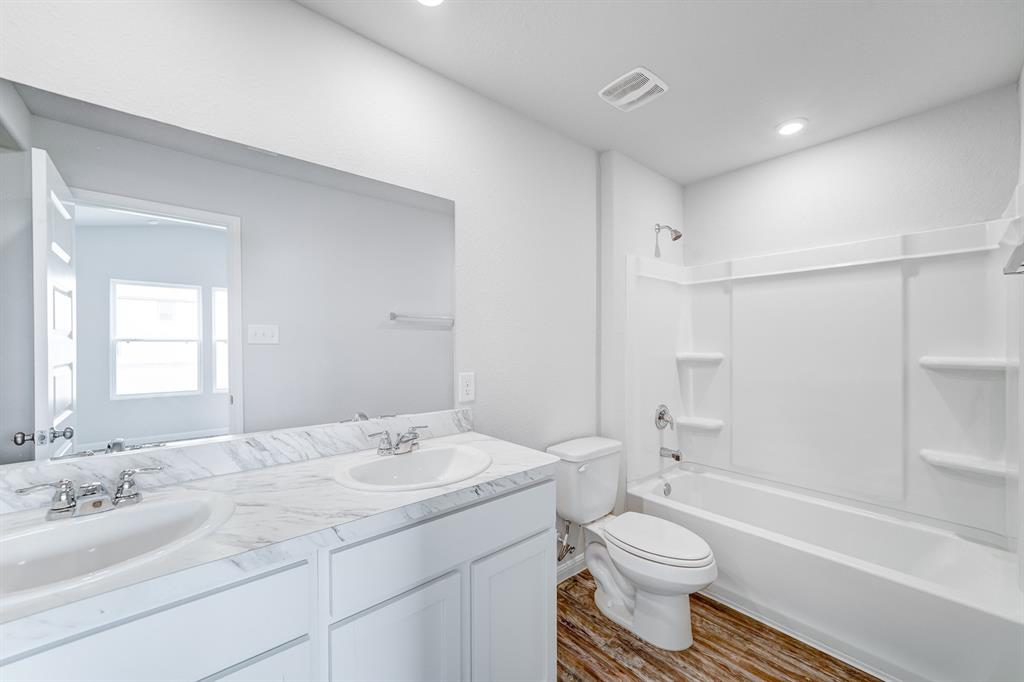 307 Victory Drive Mabank, TX 75147 - Photo 13 of 31 a bathroom with a bathtub shower sink vanity mirror and toilet