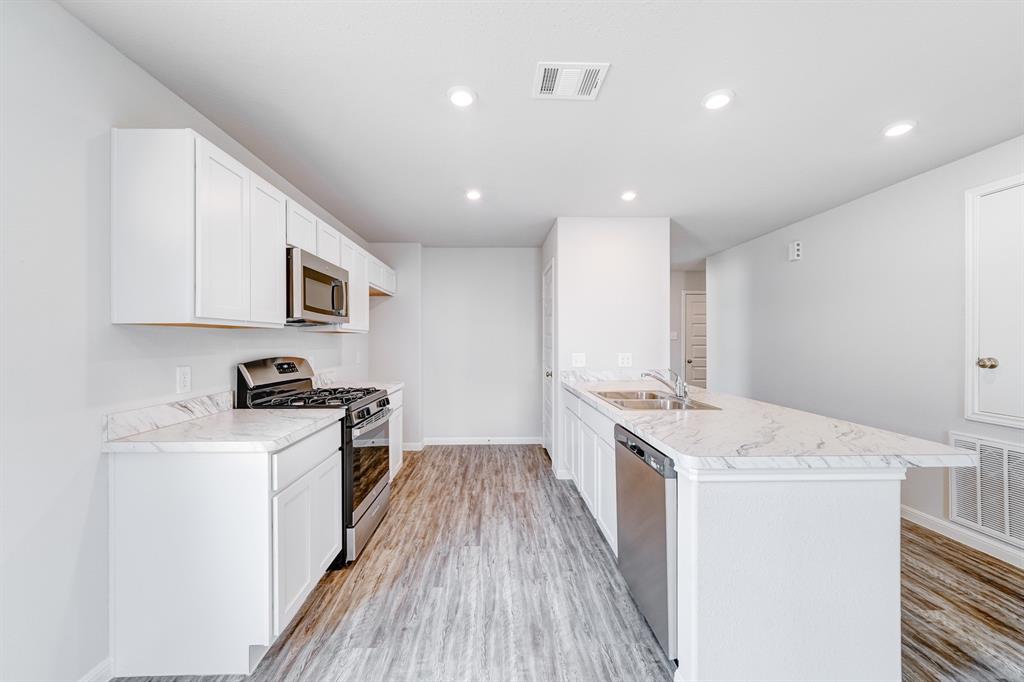 307 Victory Drive Mabank, TX 75147 - Photo 21 of 31 a kitchen with a sink stove top oven and white cabinets