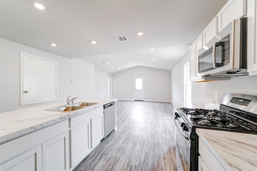 307 Victory Drive Mabank, TX 75147 - Photo 29 of 31 a kitchen with stainless steel appliances a stove a sink and a refrigerator
