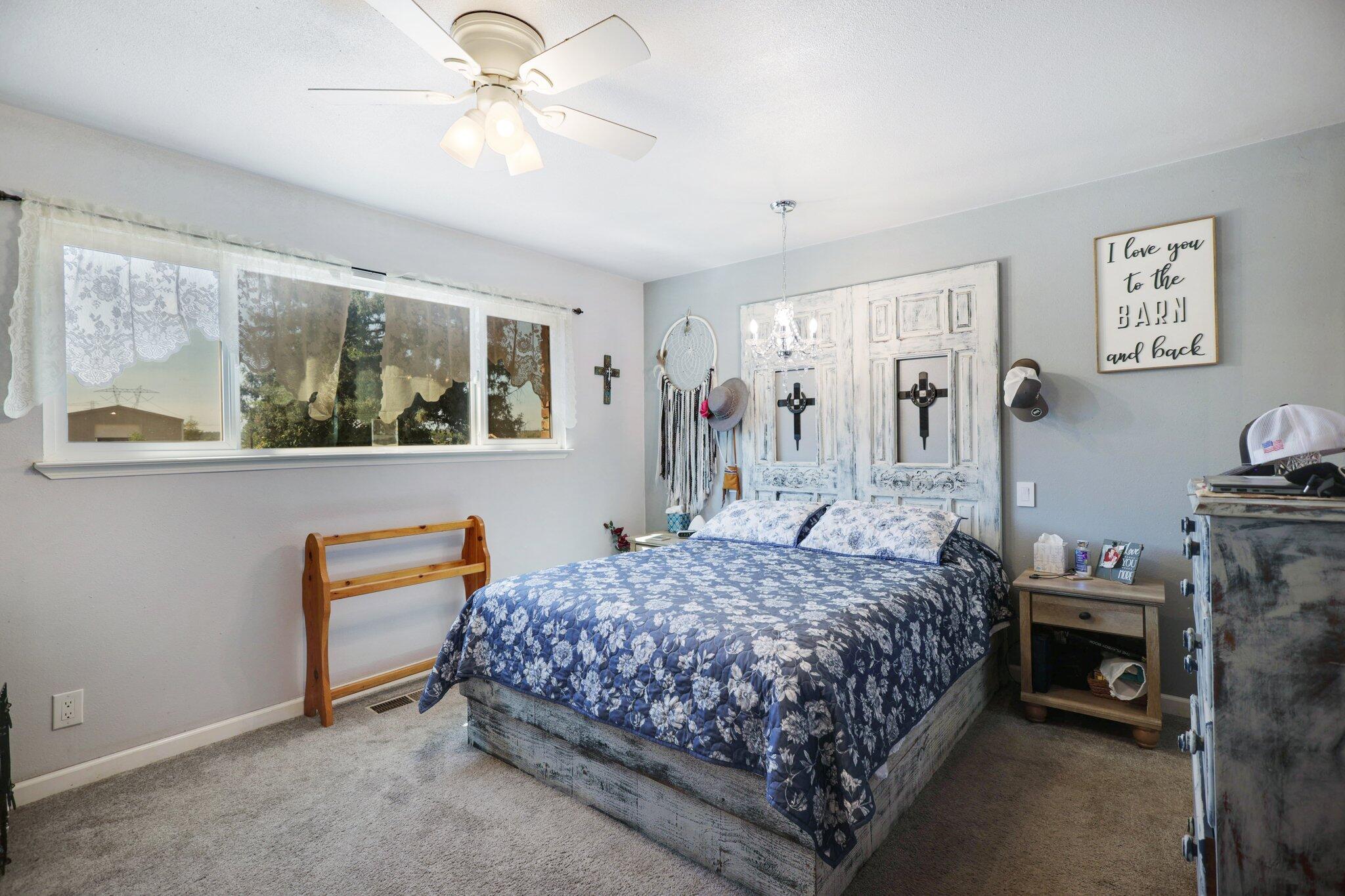 5078 Balls Ferry Road Anderson, CA 96007 - Photo 21 of 113 a bedroom with a bed and a chandelier