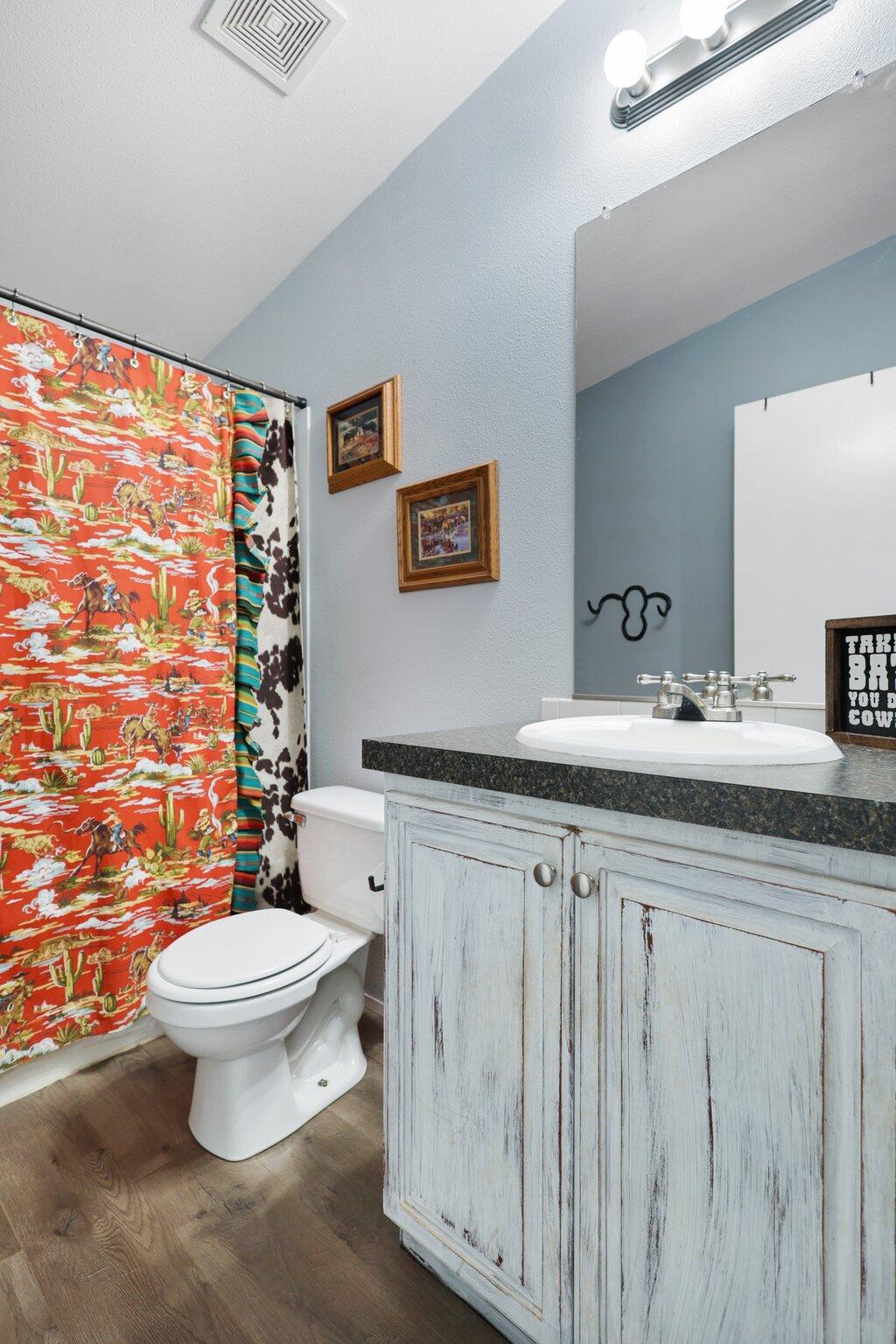 5078 Balls Ferry Road Anderson, CA 96007 - Photo 72 of 113 a bathroom with a granite countertop toilet a sink a mirror and a shower