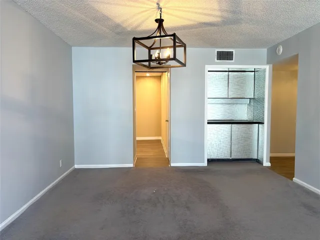a view of empty room with cabinet and wooden floor