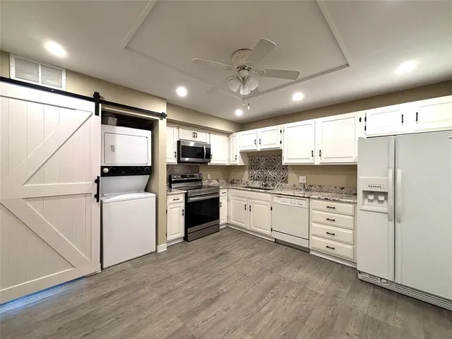 a kitchen with white cabinets and white appliances