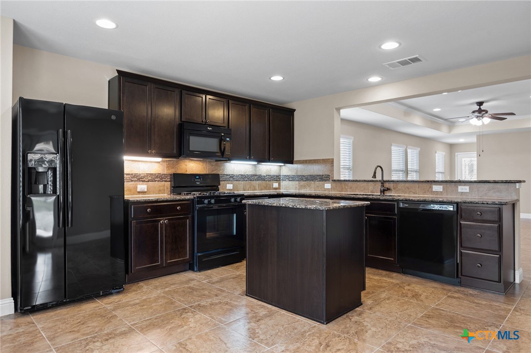 309 Kickapoo Creek Lane Georgetown, TX 78633 - Photo 11 of 28 a kitchen with stainless steel appliances granite countertop a stove and a refrigerator