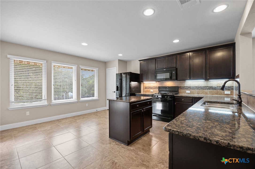 309 Kickapoo Creek Lane Georgetown, TX 78633 - Photo 12 of 28 a kitchen with stainless steel appliances granite countertop a sink stove and refrigerator