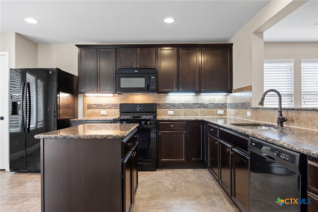 309 Kickapoo Creek Lane Georgetown, TX 78633 - Photo 13 of 28 a kitchen with stainless steel appliances granite countertop a sink stove and refrigerator