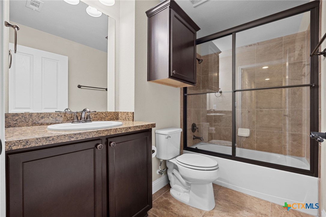 309 Kickapoo Creek Lane Georgetown, TX 78633 - Photo 21 of 28 a bathroom with a granite countertop toilet sink and mirror