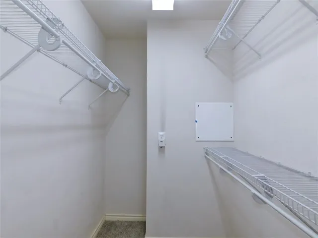 a view of walk in closet with empty racks