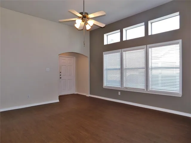 an empty room with a window and a fan