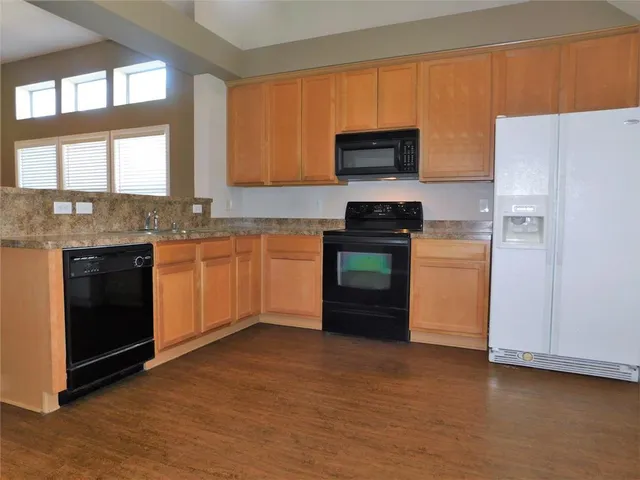 a kitchen with stainless steel appliances granite countertop a stove a sink dishwasher and a refrigerator