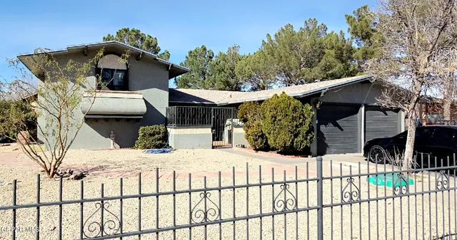 a view of a white house with wooden fence and floor