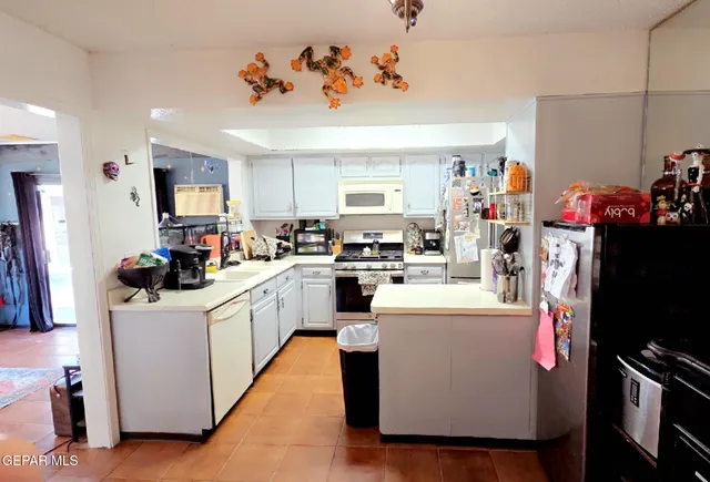 a kitchen with kitchen island a sink appliances cabinets and a counter top space