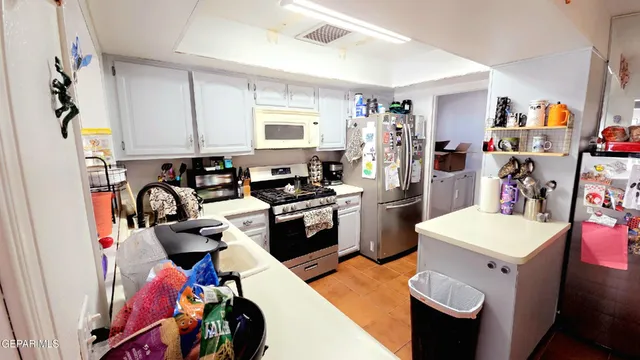 a view of a kitchen with fridge and workspace