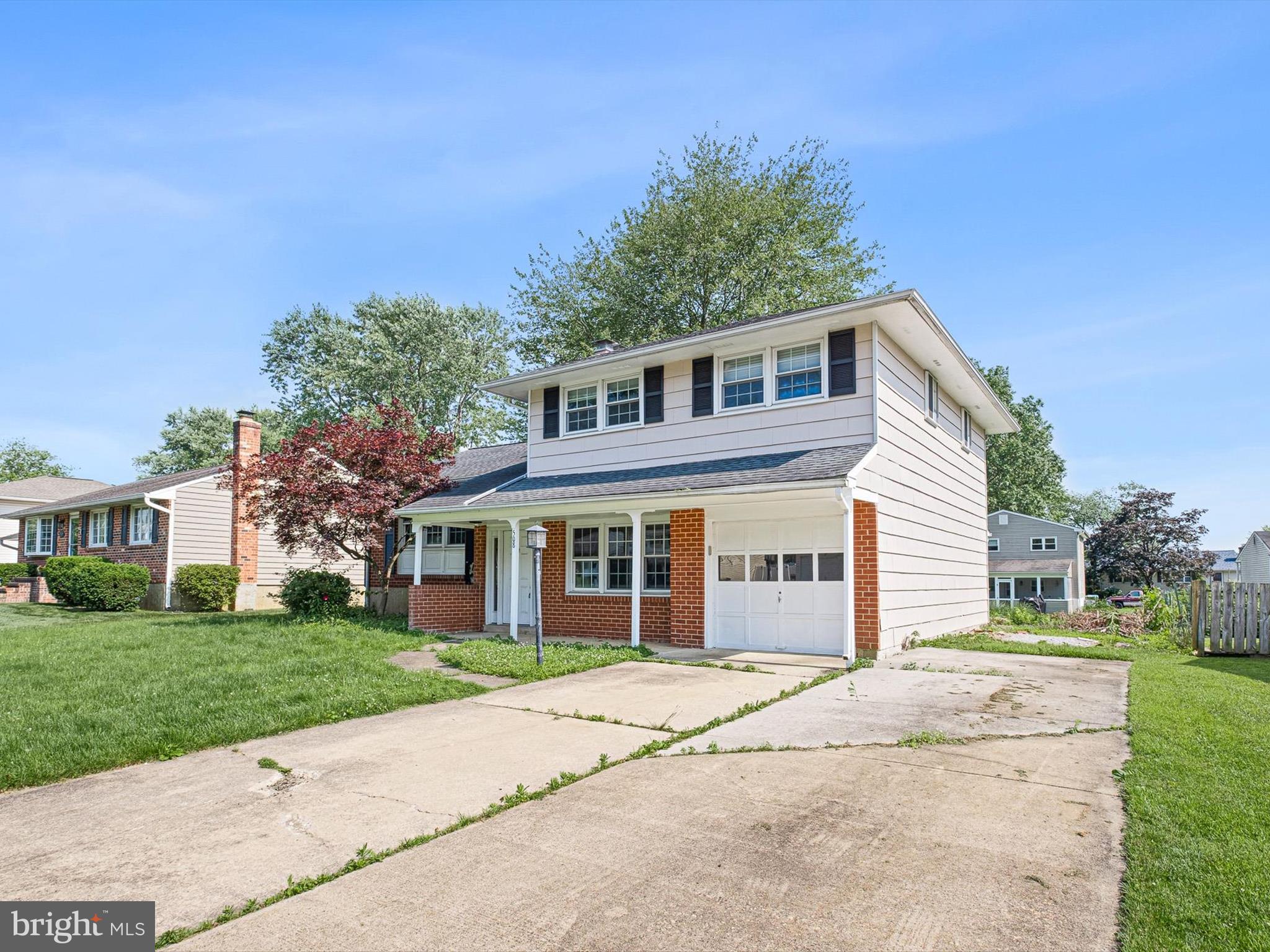 508 Garrick Road Hockessin, DE 19707 - Photo 2 of 25 a front view of a house with a garden and trees