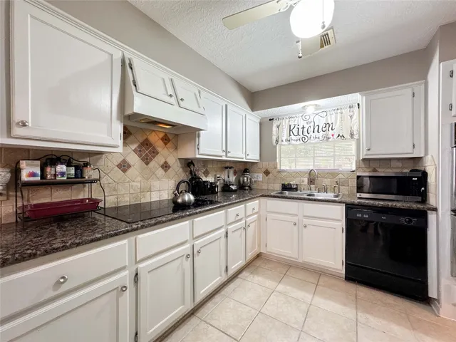 a kitchen with a sink a counter top space cabinets and stainless steel appliances