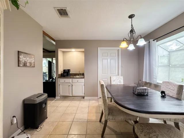a kitchen with a dining table chairs and refrigerator