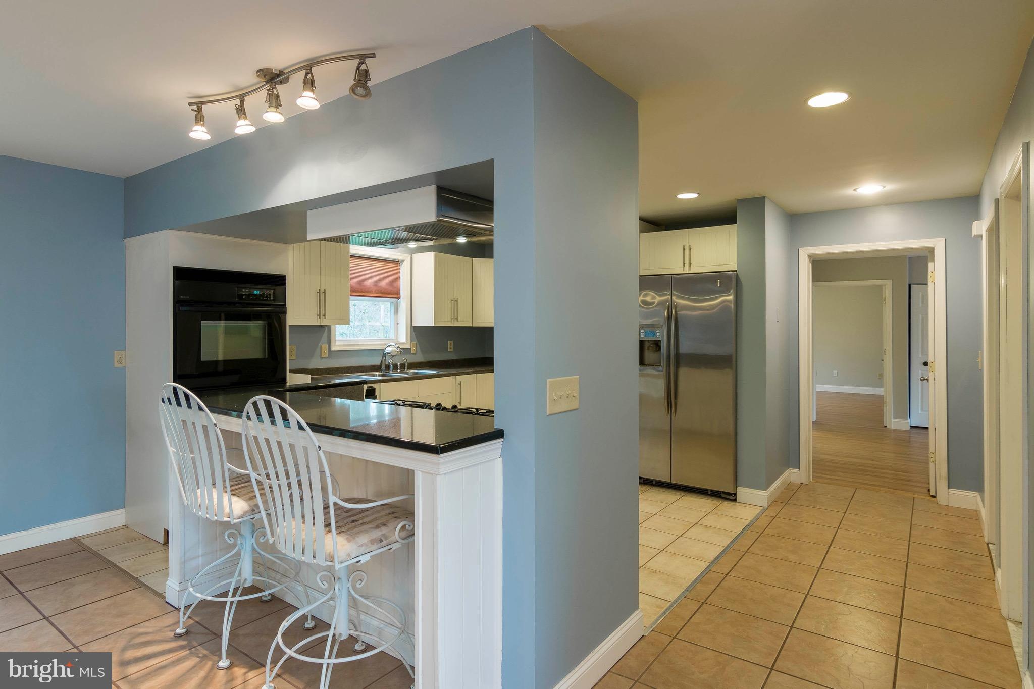 a kitchen with stainless steel appliances granite countertop a sink and a refrigerator