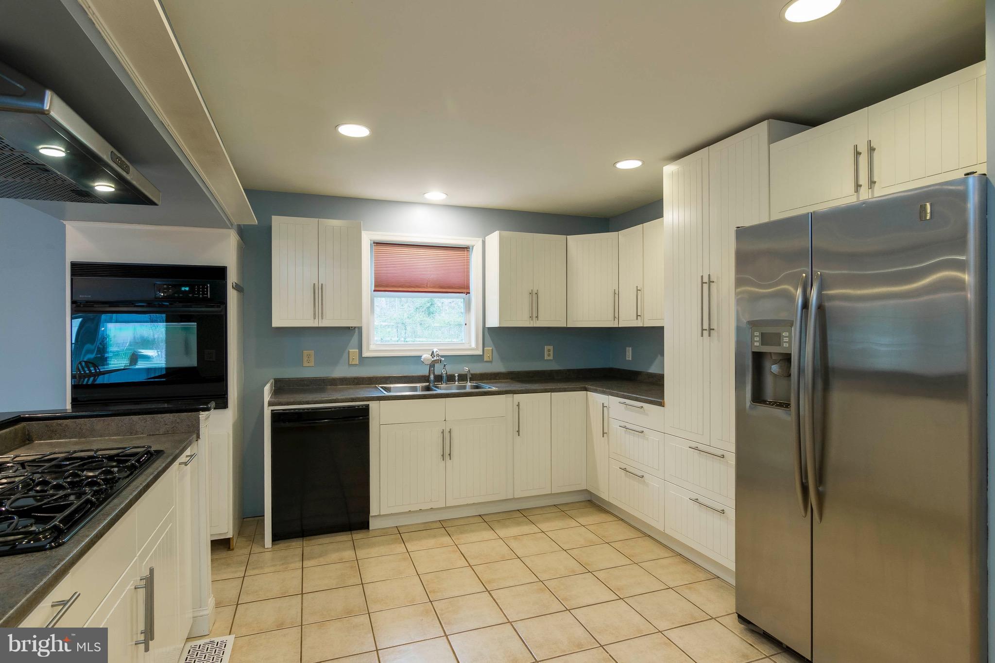 5901 Shady Spring Avenue Baltimore, MD 21237 - Photo 11 of 30 a kitchen with granite countertop a refrigerator and a stove top oven