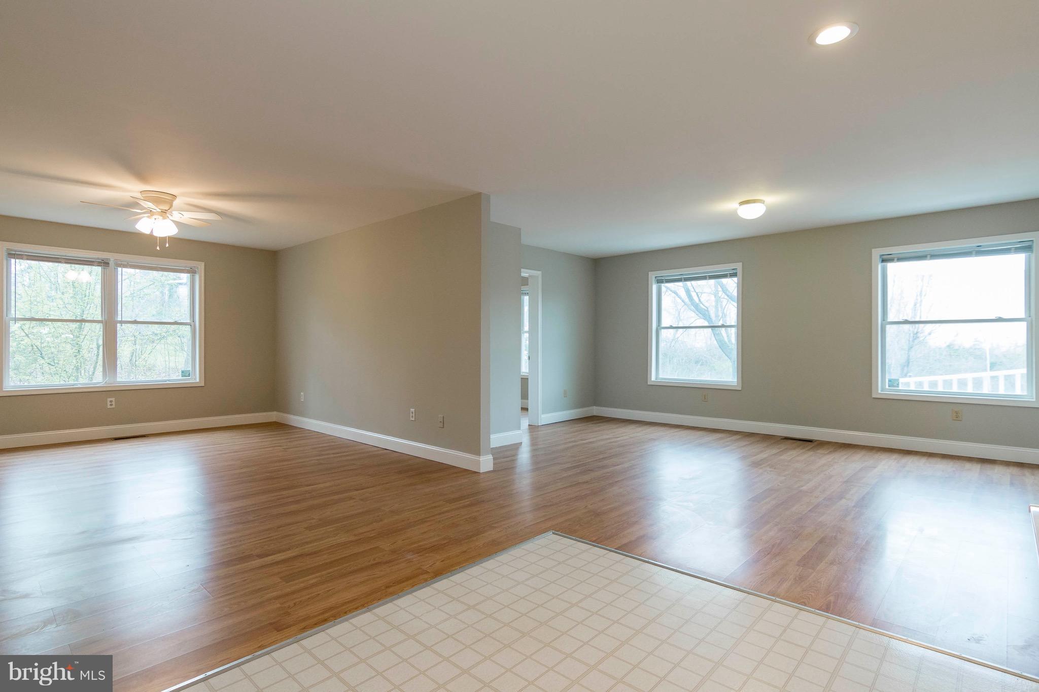 5901 Shady Spring Avenue Baltimore, MD 21237 - Photo 12 of 30 an empty room with wooden floor and windows