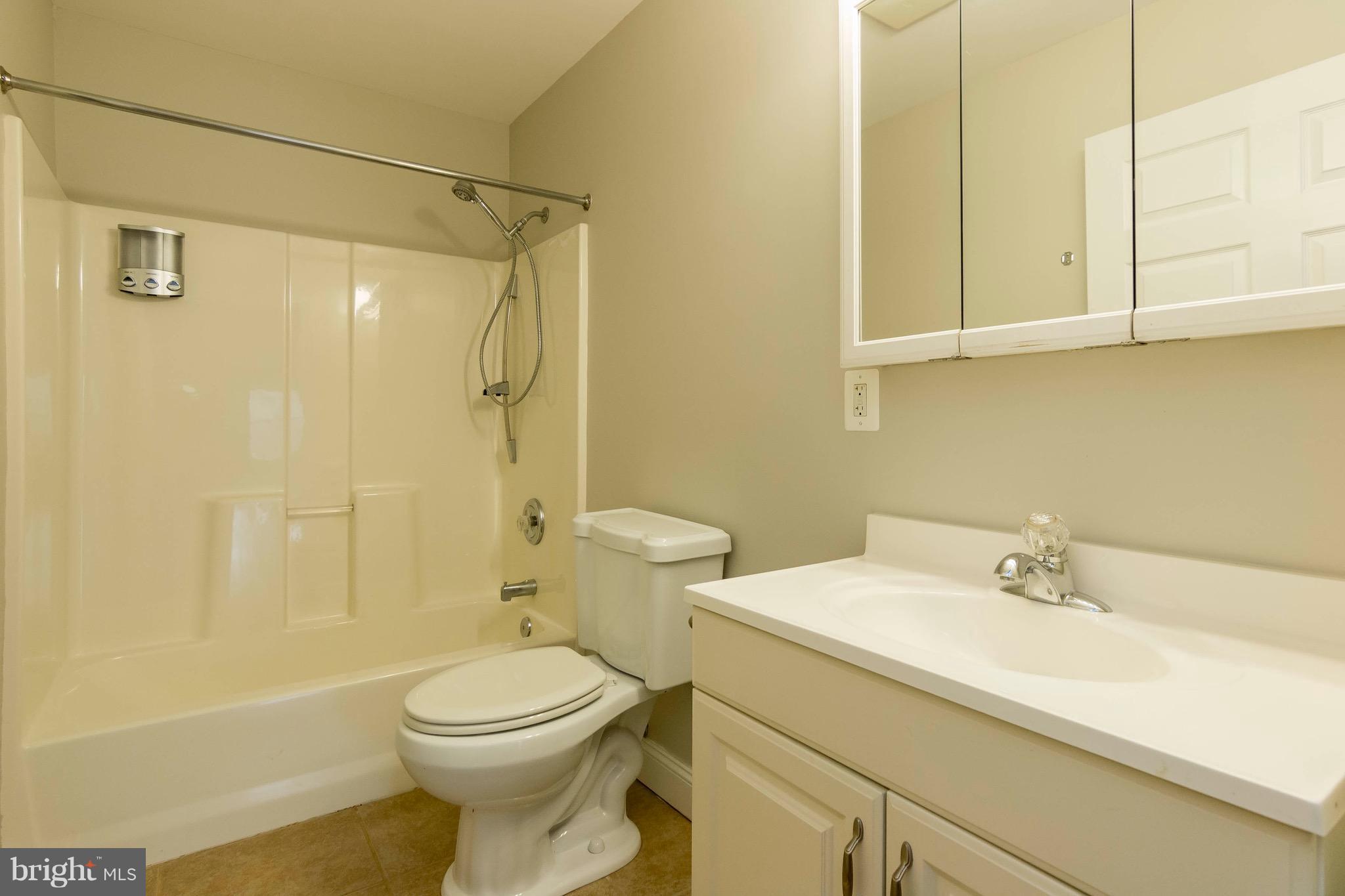 5901 Shady Spring Avenue Baltimore, MD 21237 - Photo 14 of 30 a bathroom with a sink a toilet and shower