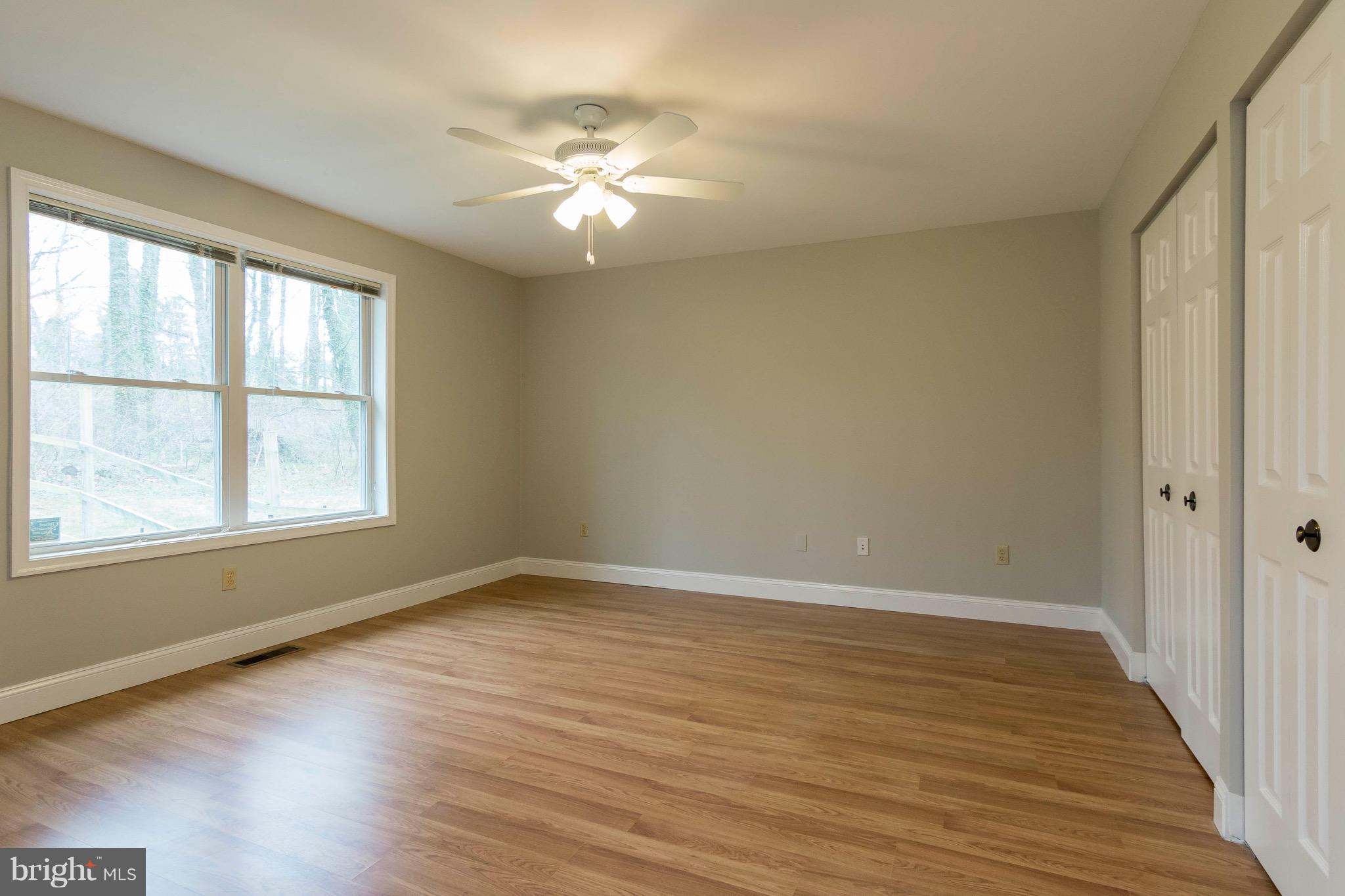 5901 Shady Spring Avenue Baltimore, MD 21237 - Photo 15 of 30 a view of an empty room with wooden floor and a window