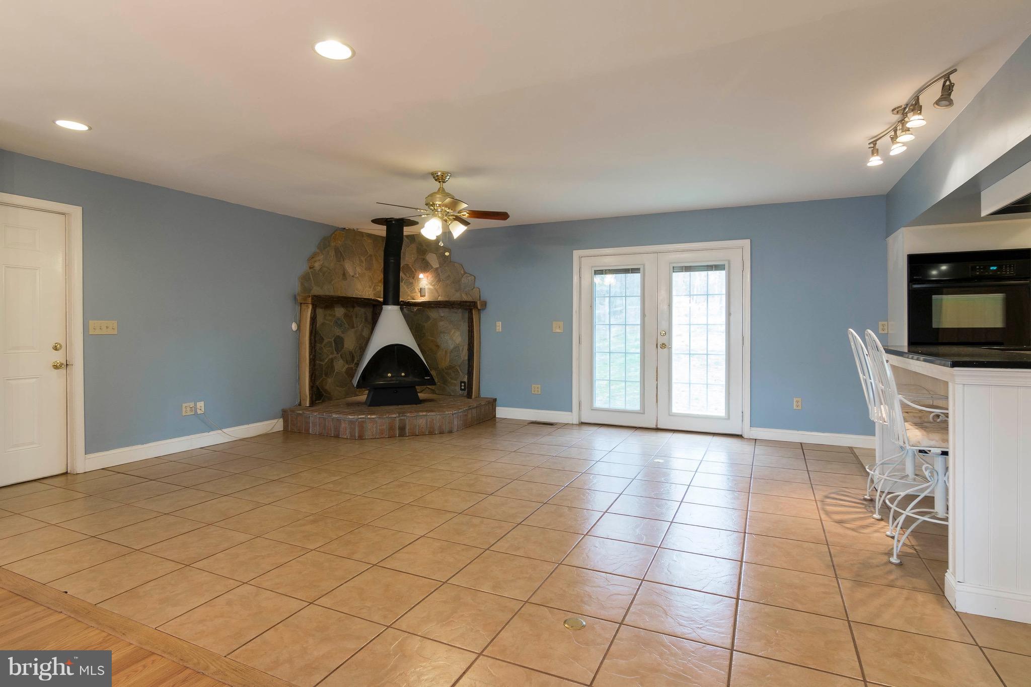 5901 Shady Spring Avenue Baltimore, MD 21237 - Photo 10 of 30 a view of empty room with wooden floor and fireplace