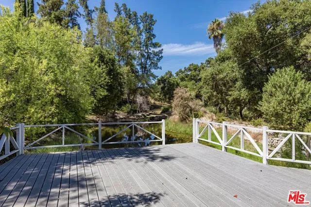 a view of a house with a yard and a large tree
