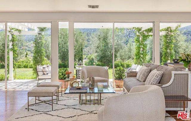 a living room with fireplace furniture and a large window