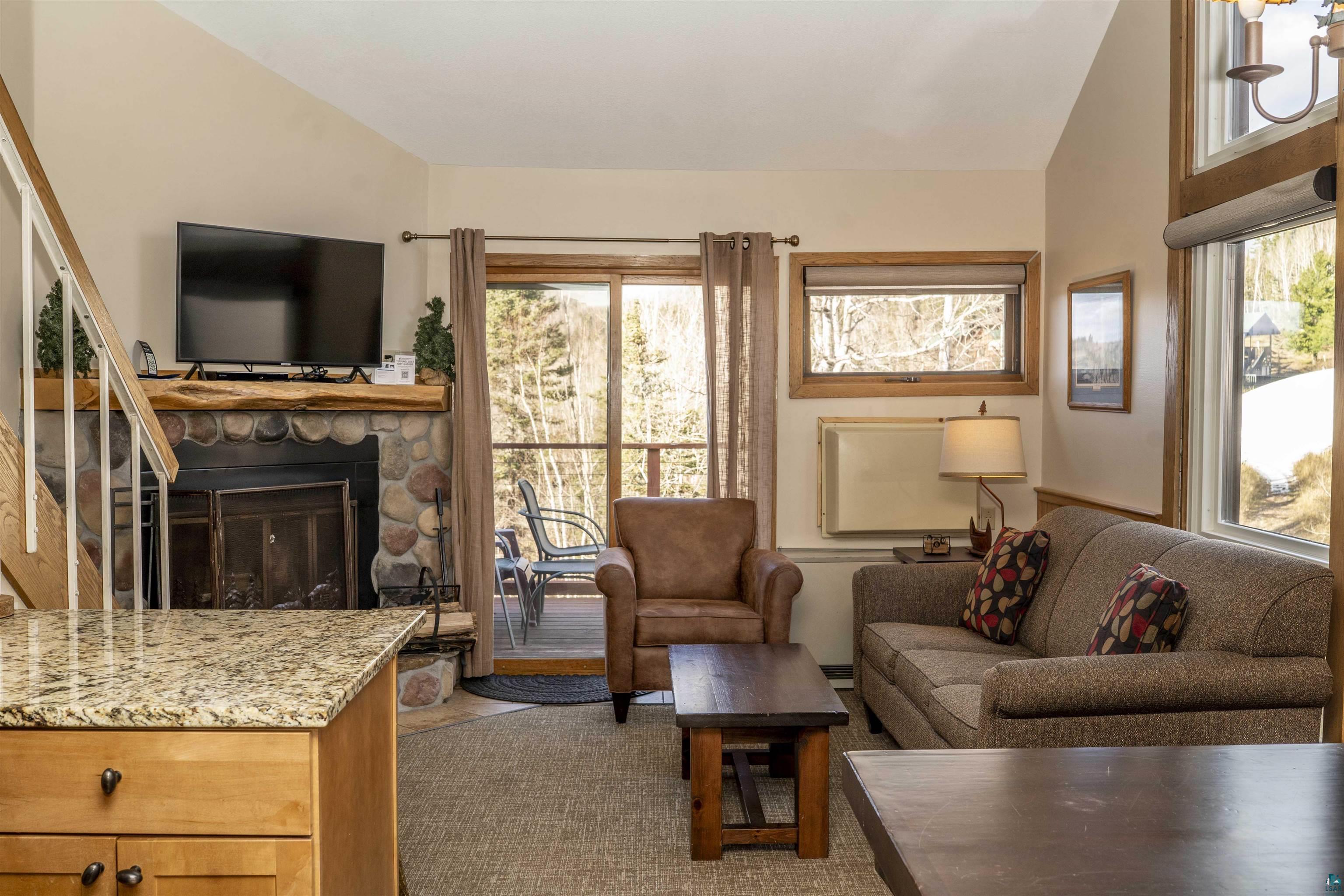 111 Bridge Run Lane, Unit 111 Lutsen, MN 55612 - Photo 2 of 48 Living area with a fireplace, lofted ceiling, and stairs