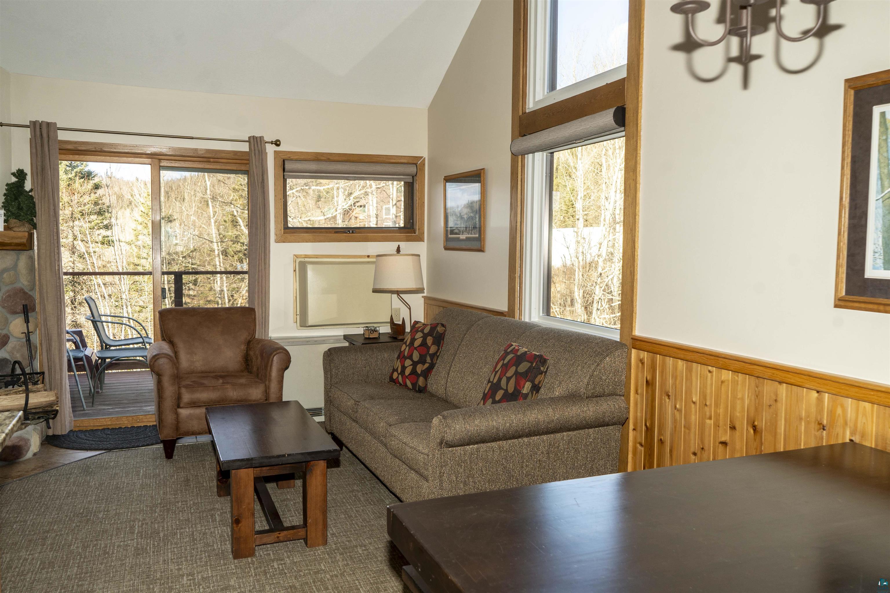 111 Bridge Run Lane, Unit 111 Lutsen, MN 55612 - Photo 25 of 48 Living room with vaulted ceiling, wainscoting, and wooden walls