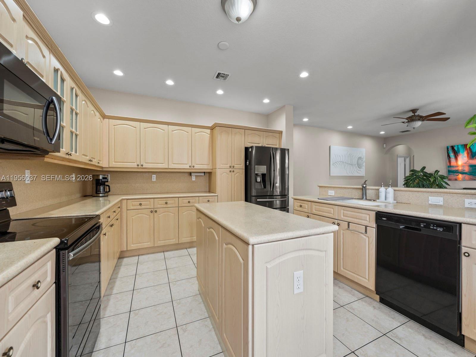 15383 Southwest 23rd Street Miami, FL 33185 - Photo 13 of 36 a kitchen with a sink a stove and cabinets