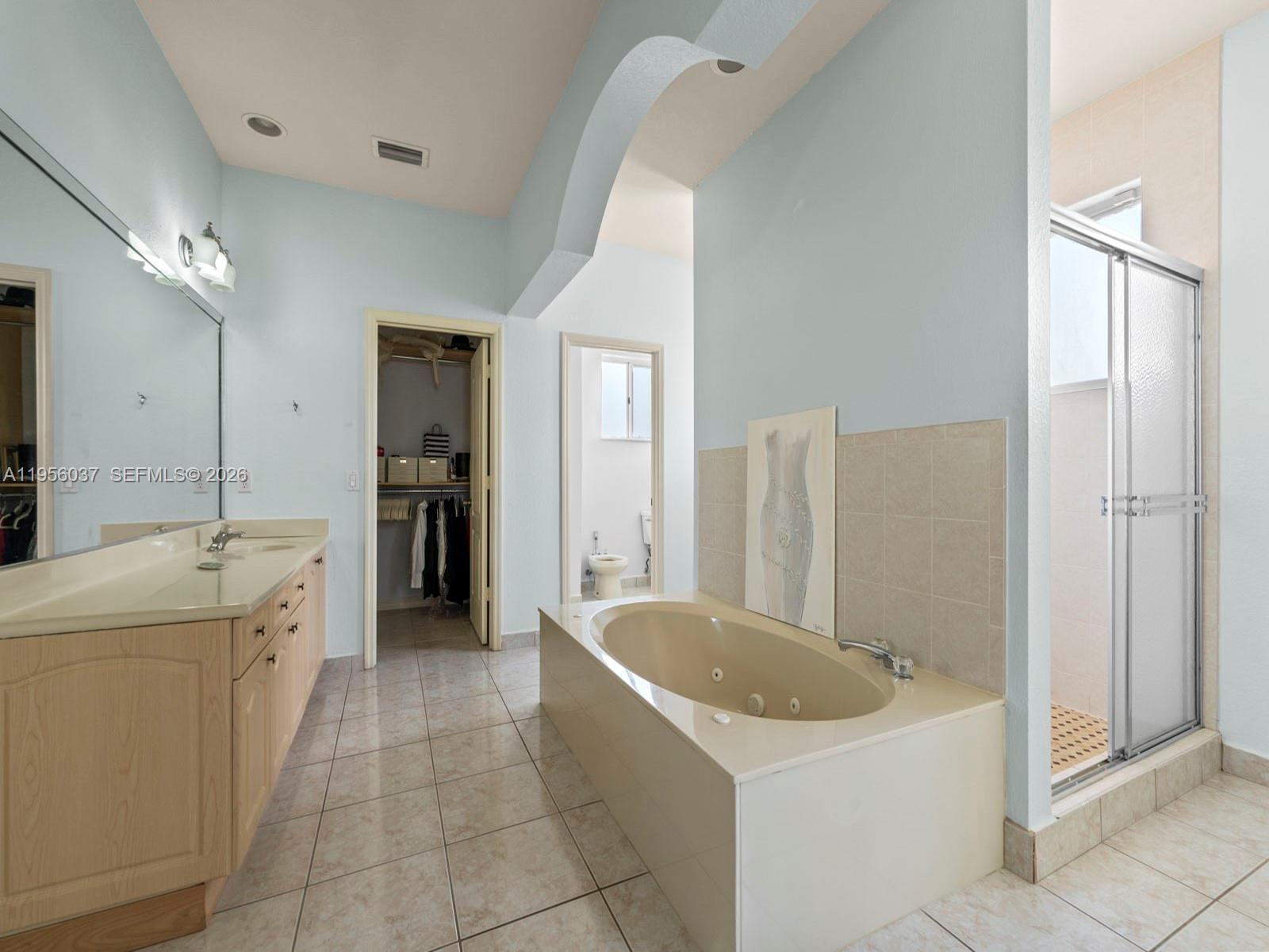 15383 Southwest 23rd Street Miami, FL 33185 - Photo 16 of 36 a bathroom with a tub a sink a mirror and a shower